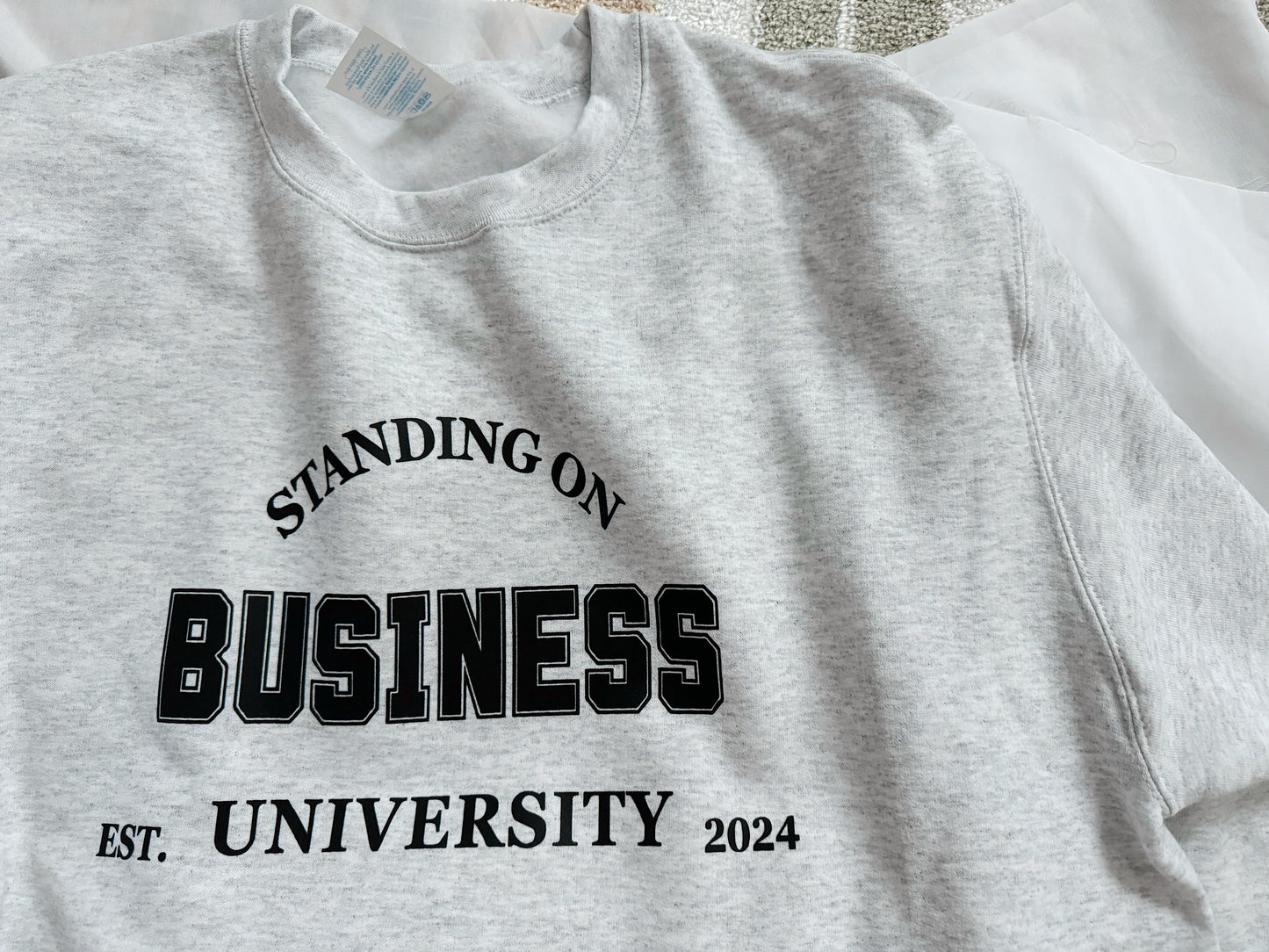 standing on business university sweatshirt